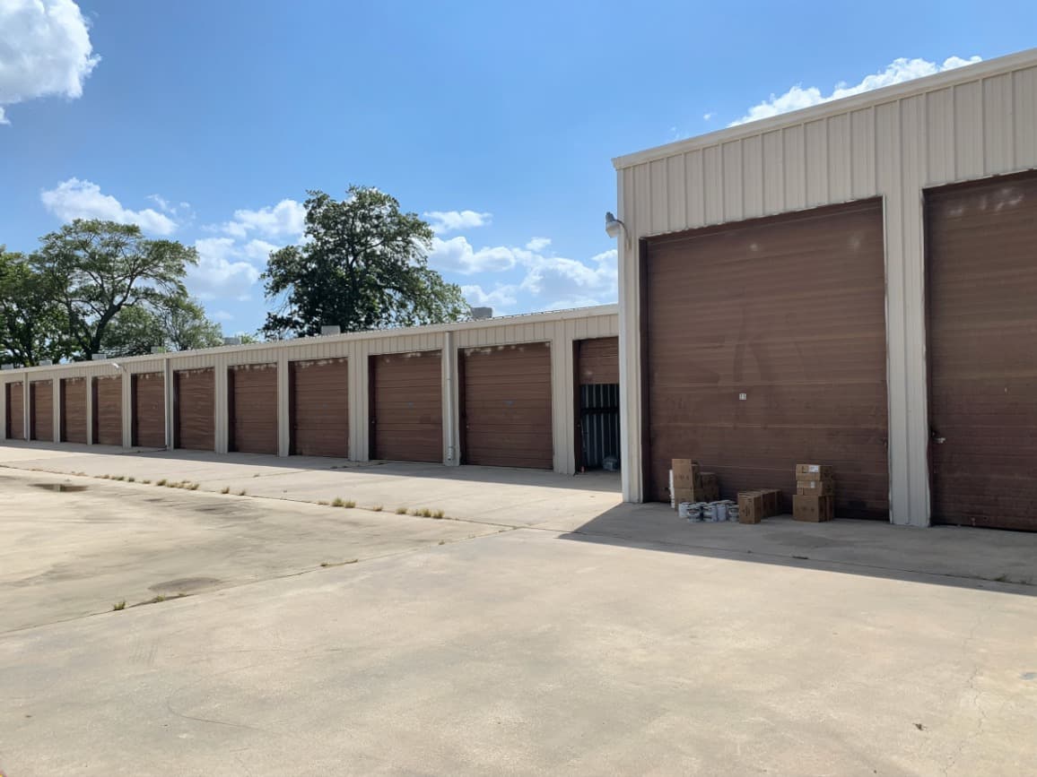 Houston storage facility with faded, worn brown roll-up doors before commercial repainting