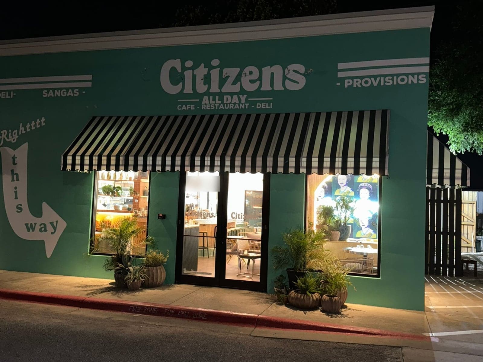 Citizens All Day restaurant in Austin with teal painted walls, large white Citizens lettering and a striped awning