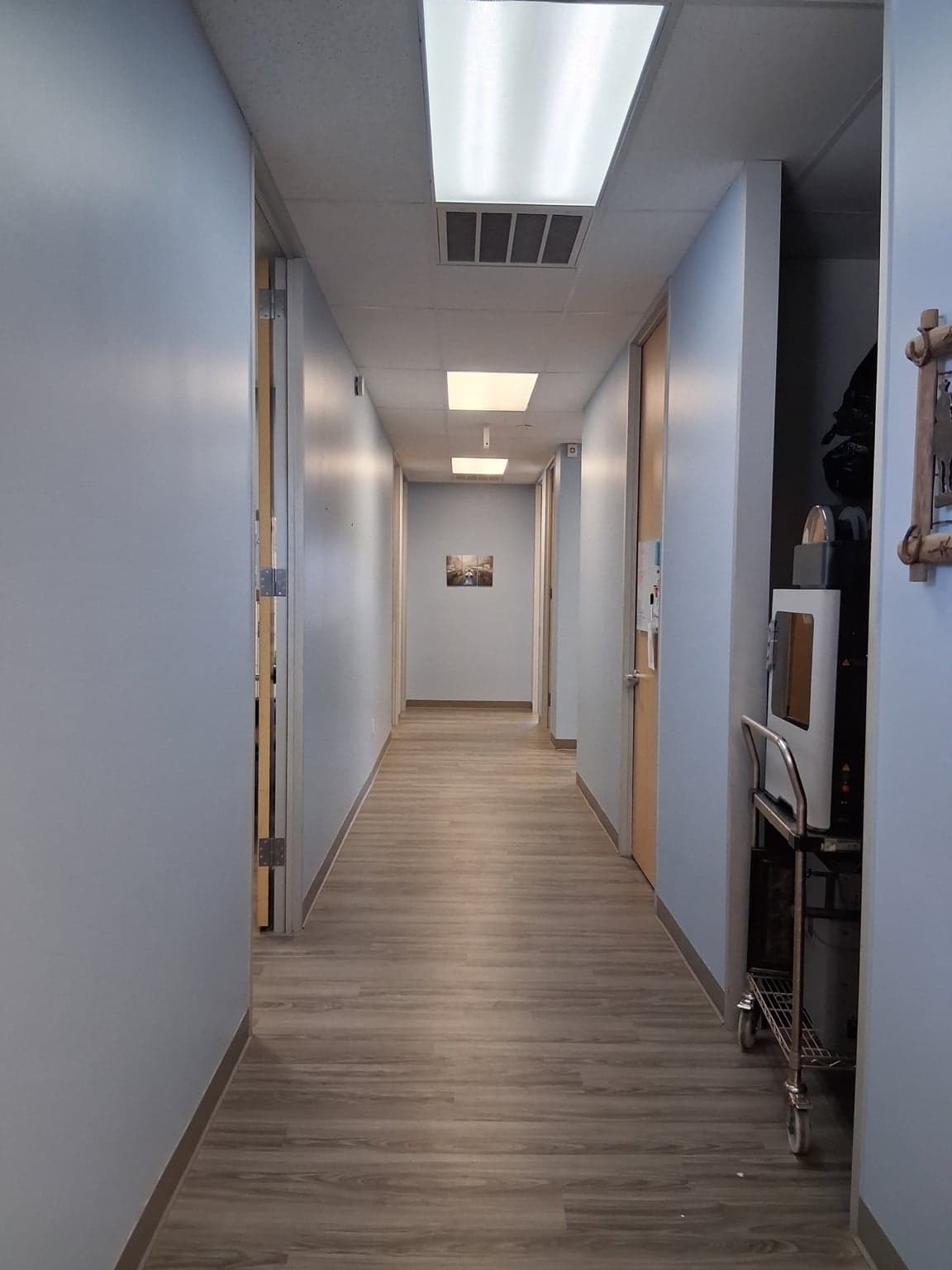 Long office hallway after painting, with soft-blue walls