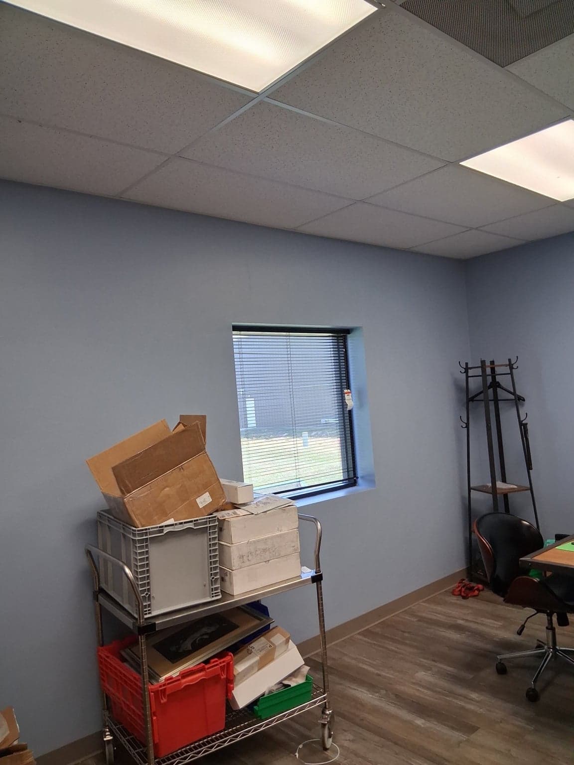 Office with soft-blue walls painted around a recessed window