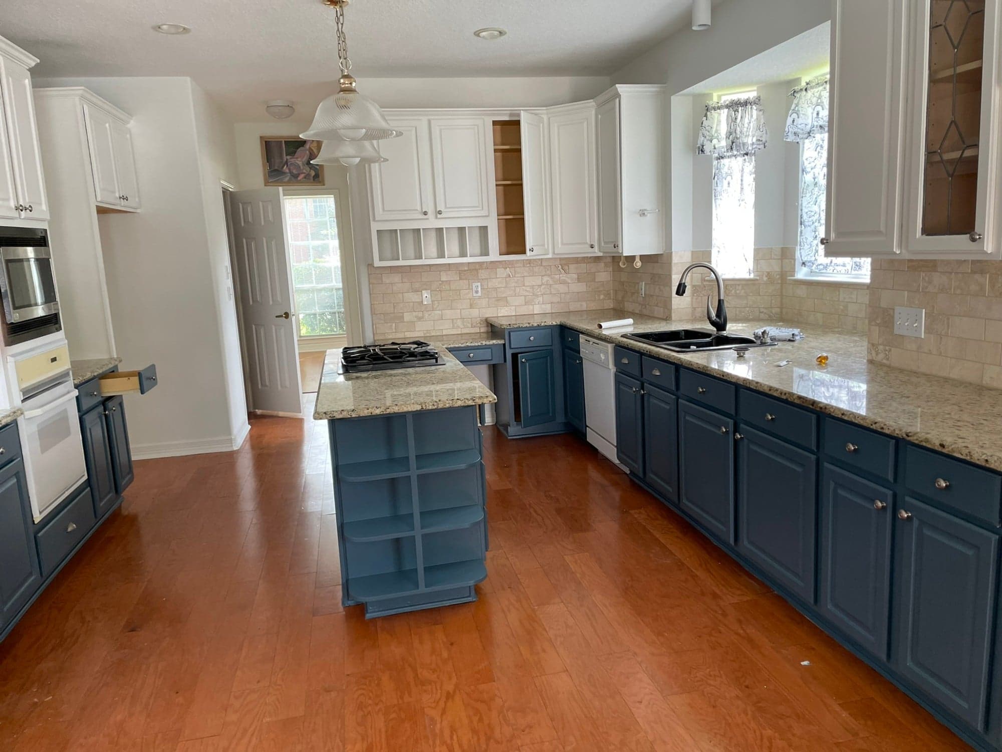 Cypress kitchen with blue painted lower cabinets and island, white painted upper cabinets and granite counters