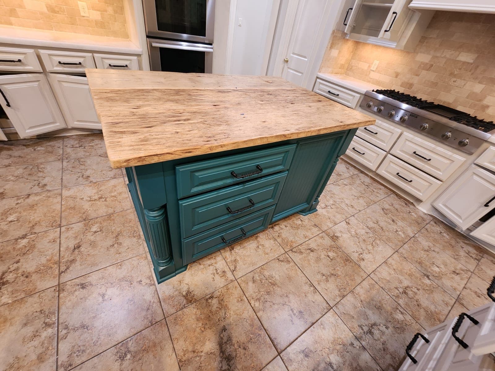 Close view of the teal island drawers, beadboard panel and fluted corner posts