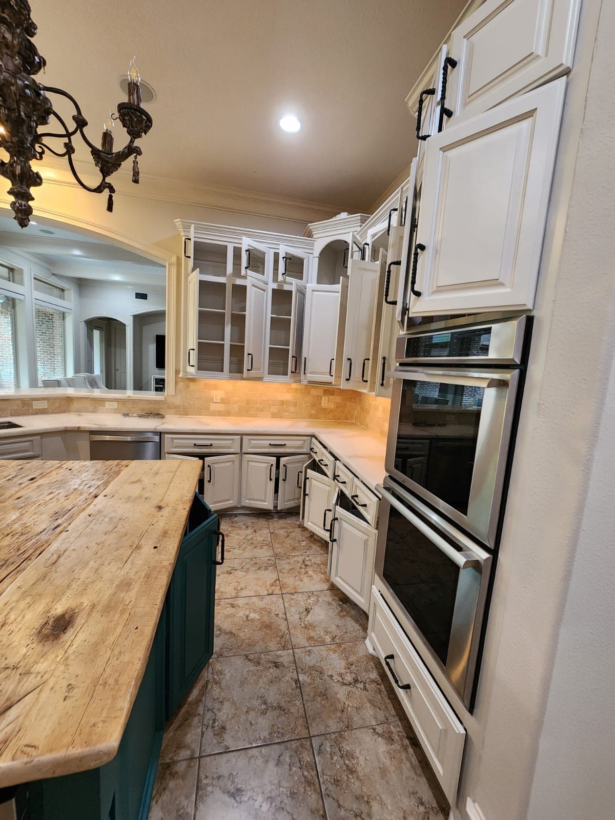 White upper cabinets and the tall cabinet around the double wall ovens