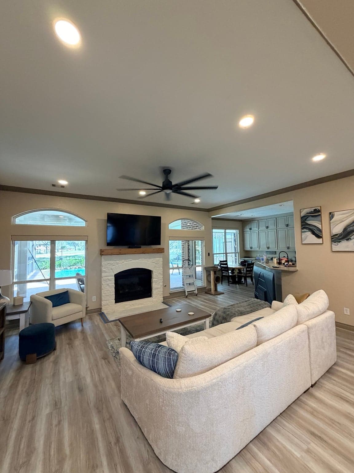 Living room fireplace wall with arched transom windows, beige walls and taupe crown molding