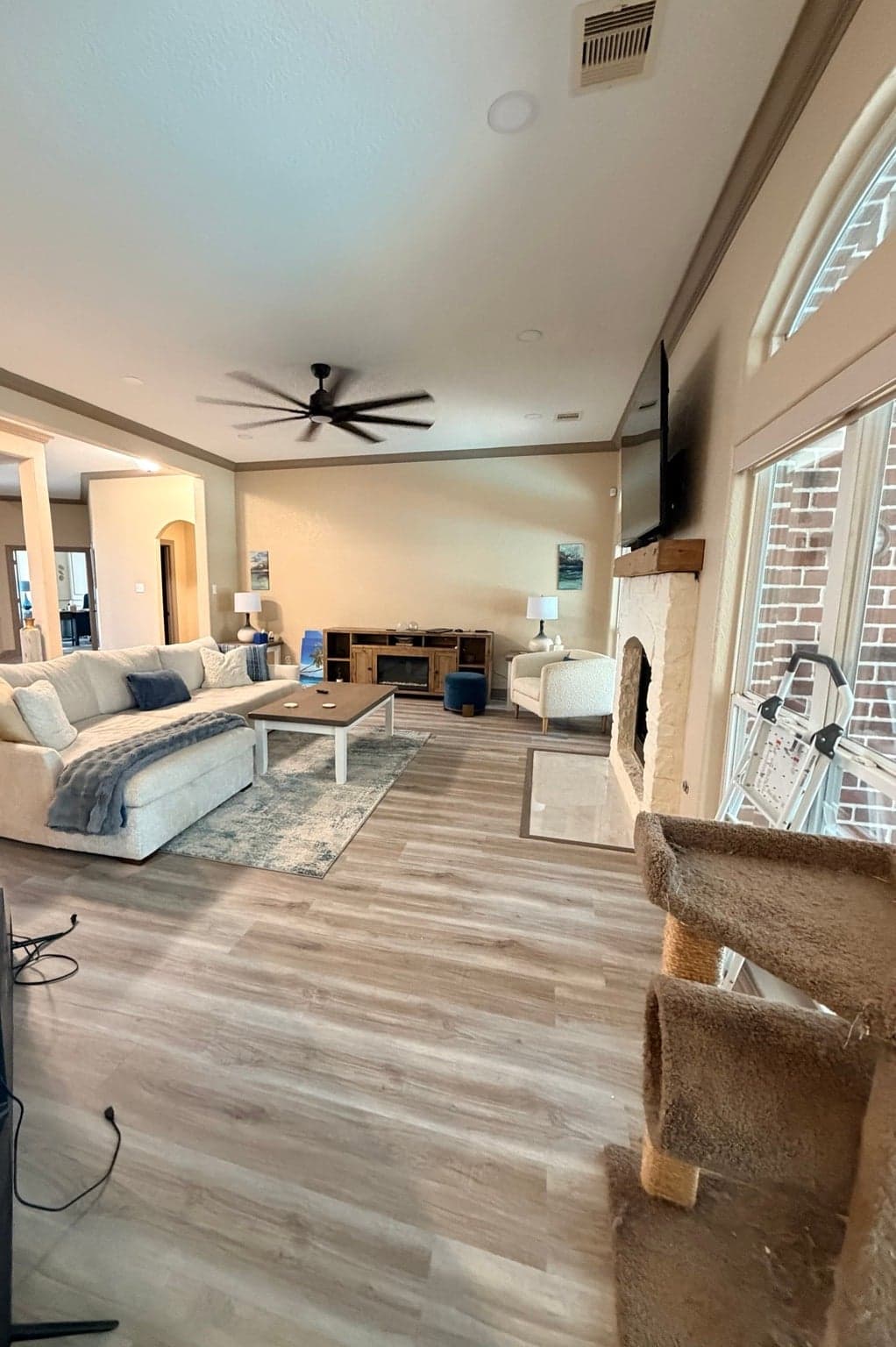 Wide view of the living room toward the entry, with beige walls and taupe trim