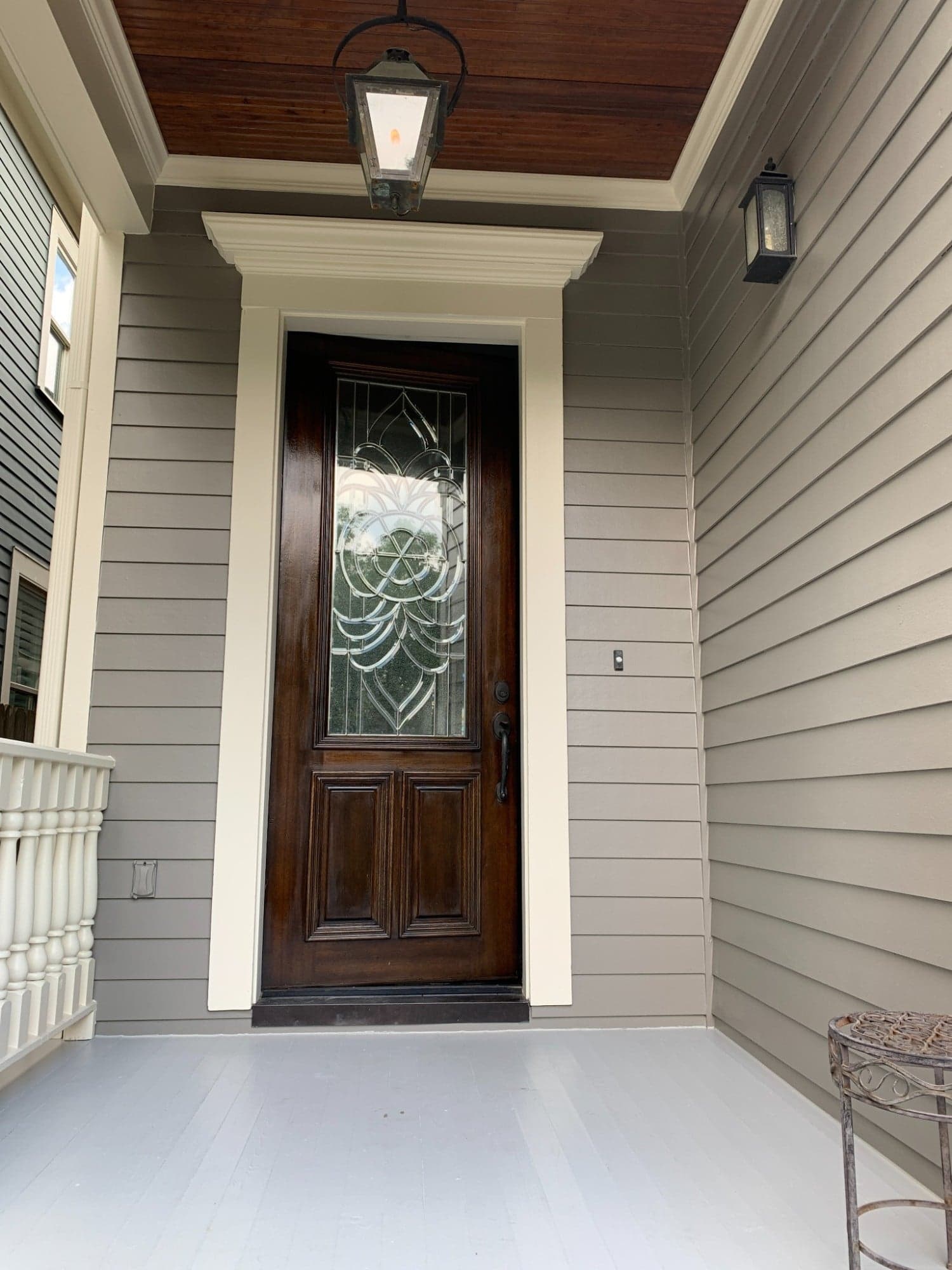Front entry with gray siding, cream door casing and crown, and a gray porch floor