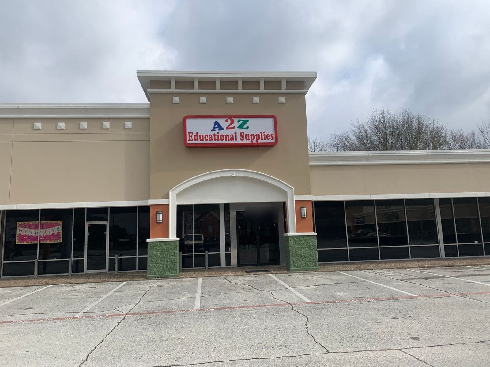Storefront entry under a white arch, with orange columns and green block bases