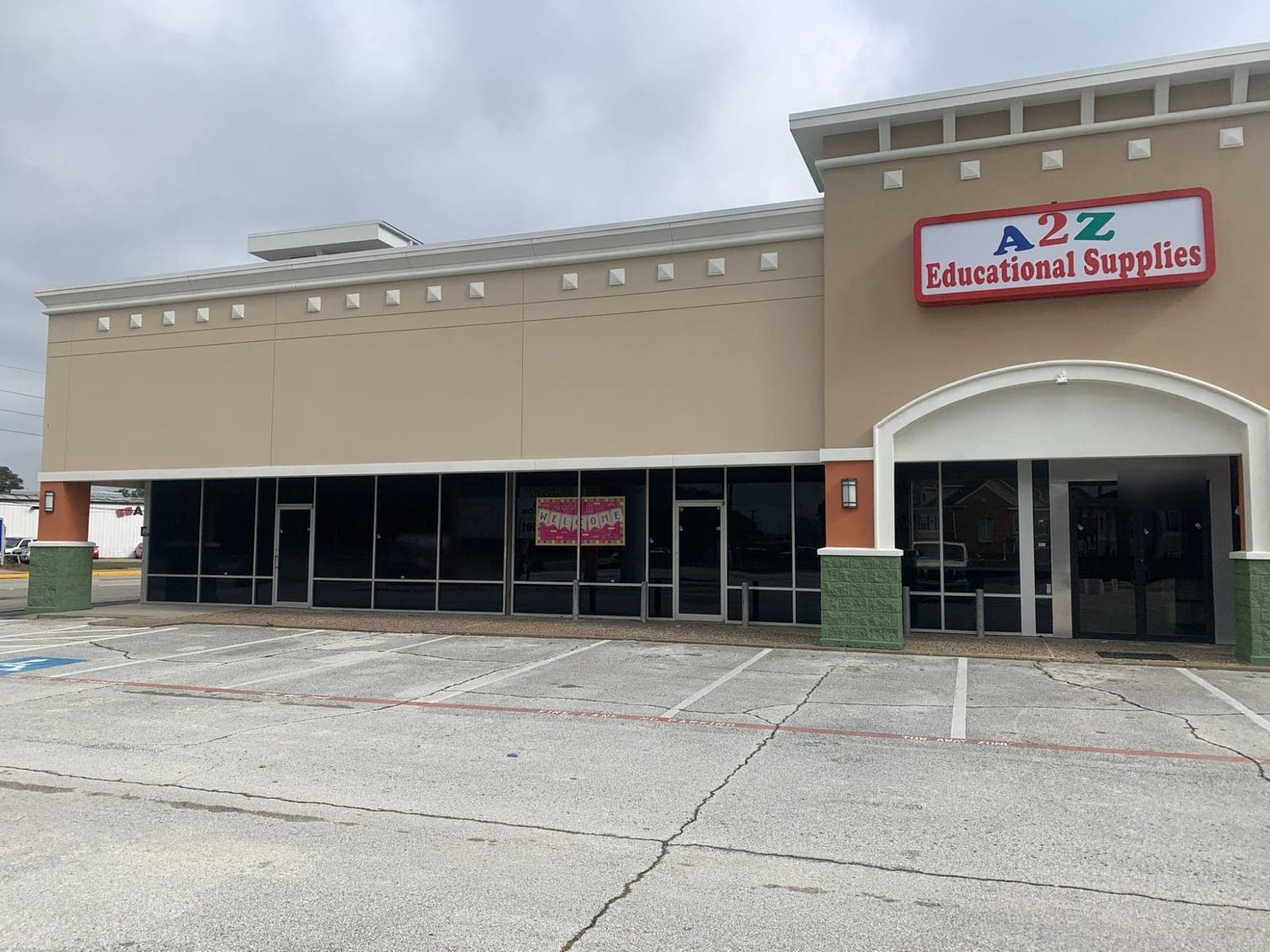 End unit of the retail center with tan stucco, white cornice and arch