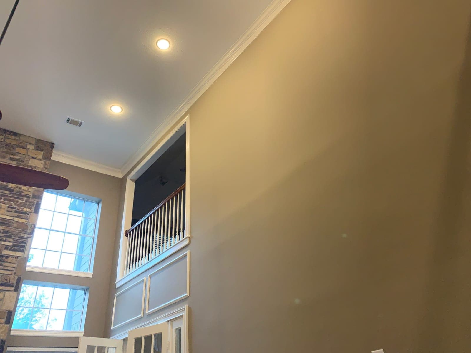 Upper great room wall with white crown molding and the trimmed balcony opening
