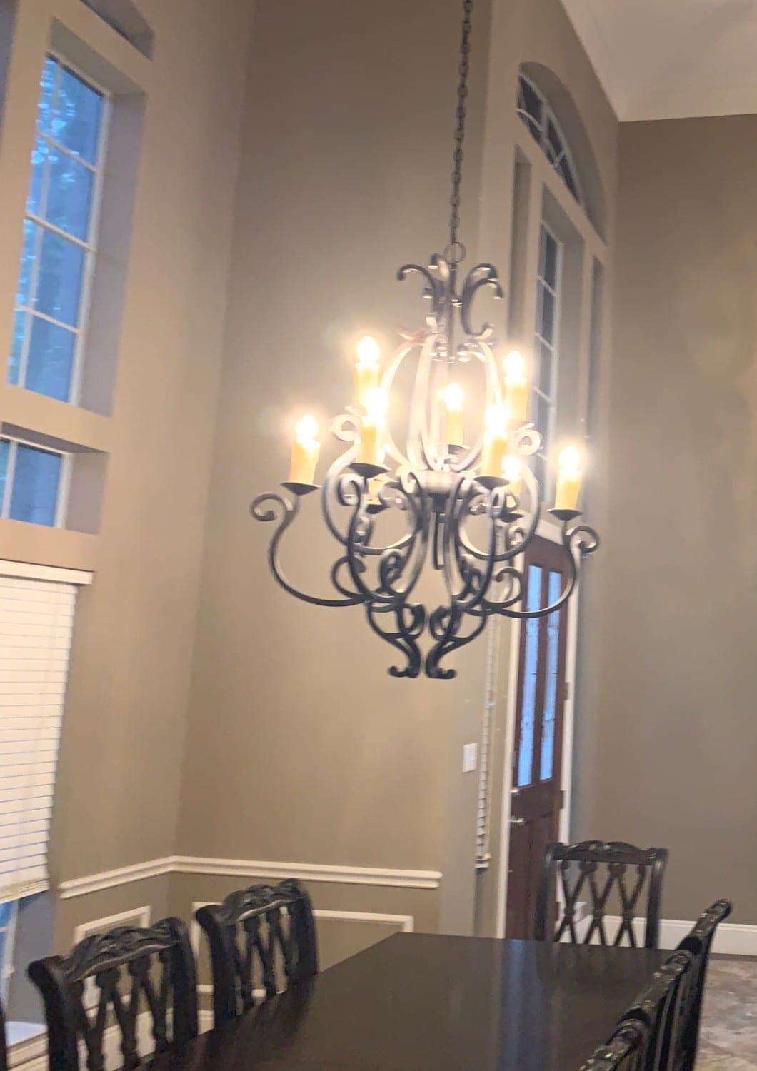 Dining room with taupe walls, white chair rail and wainscot panels and tall windows