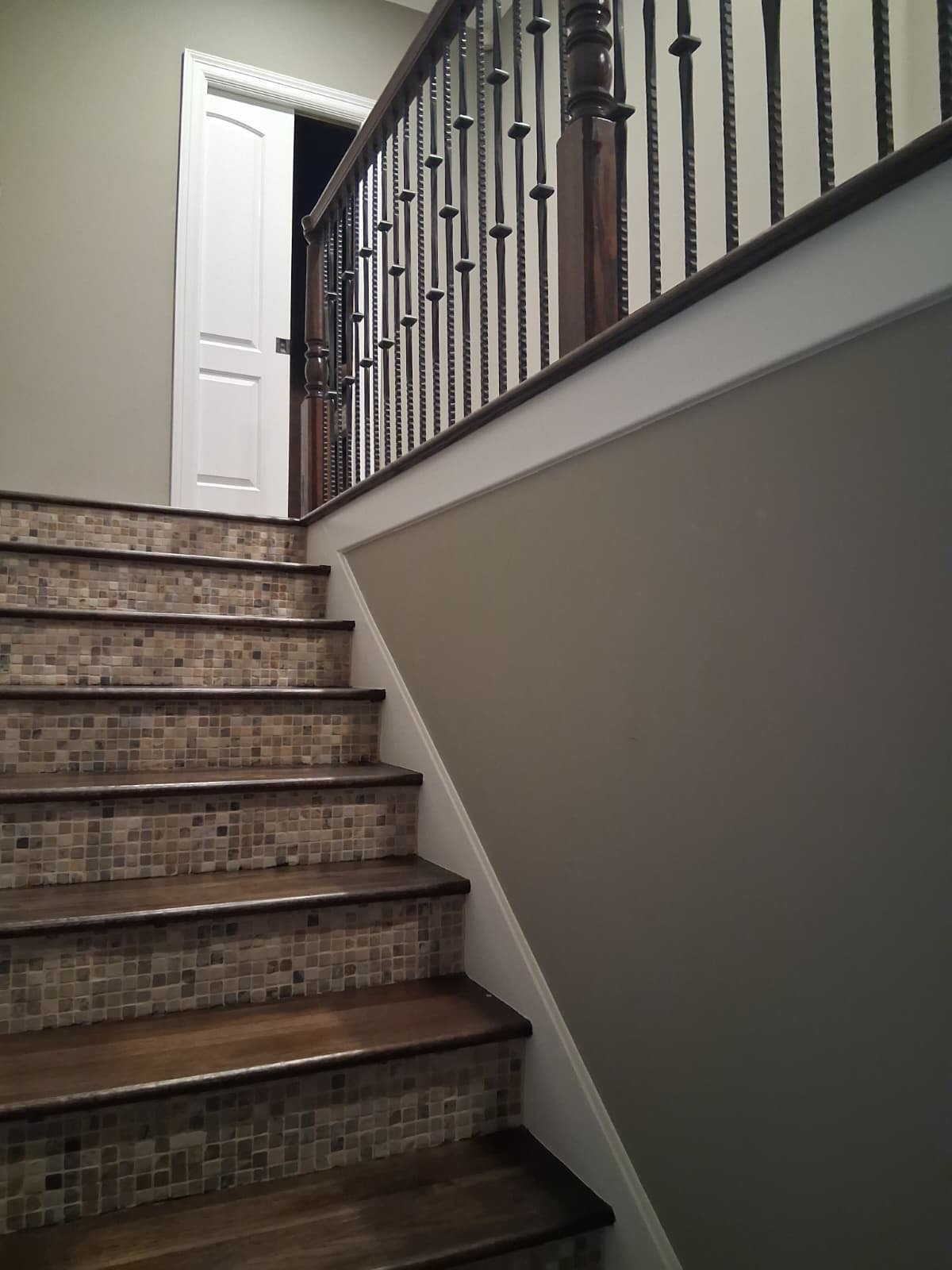 Stairwell wall in greige with white skirt board below the railing