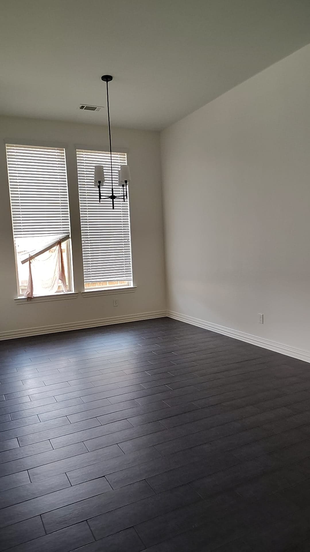 Dining room with white walls and baseboards and tall windows