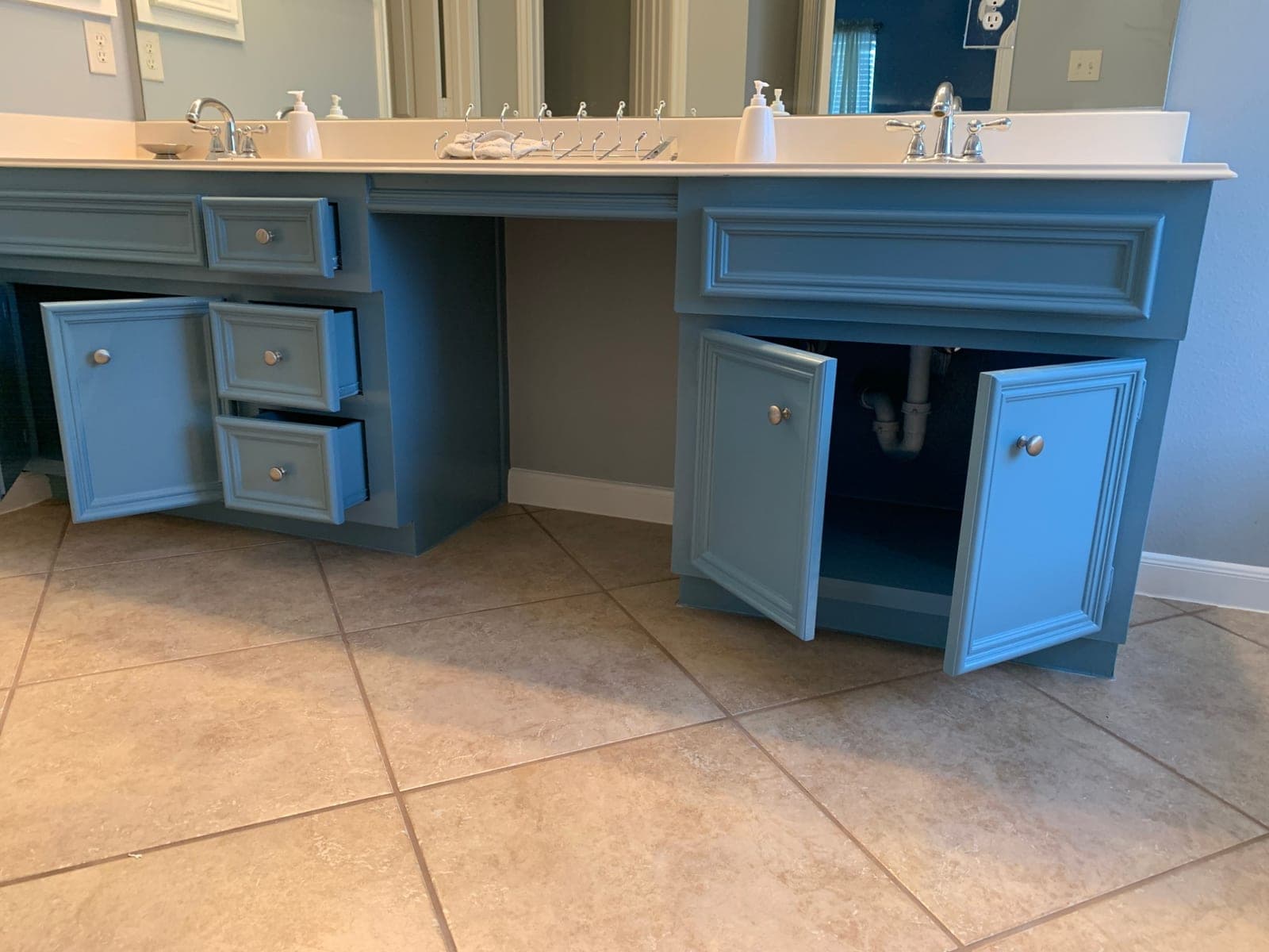 Double bathroom vanity with raised-panel doors and drawers painted blue