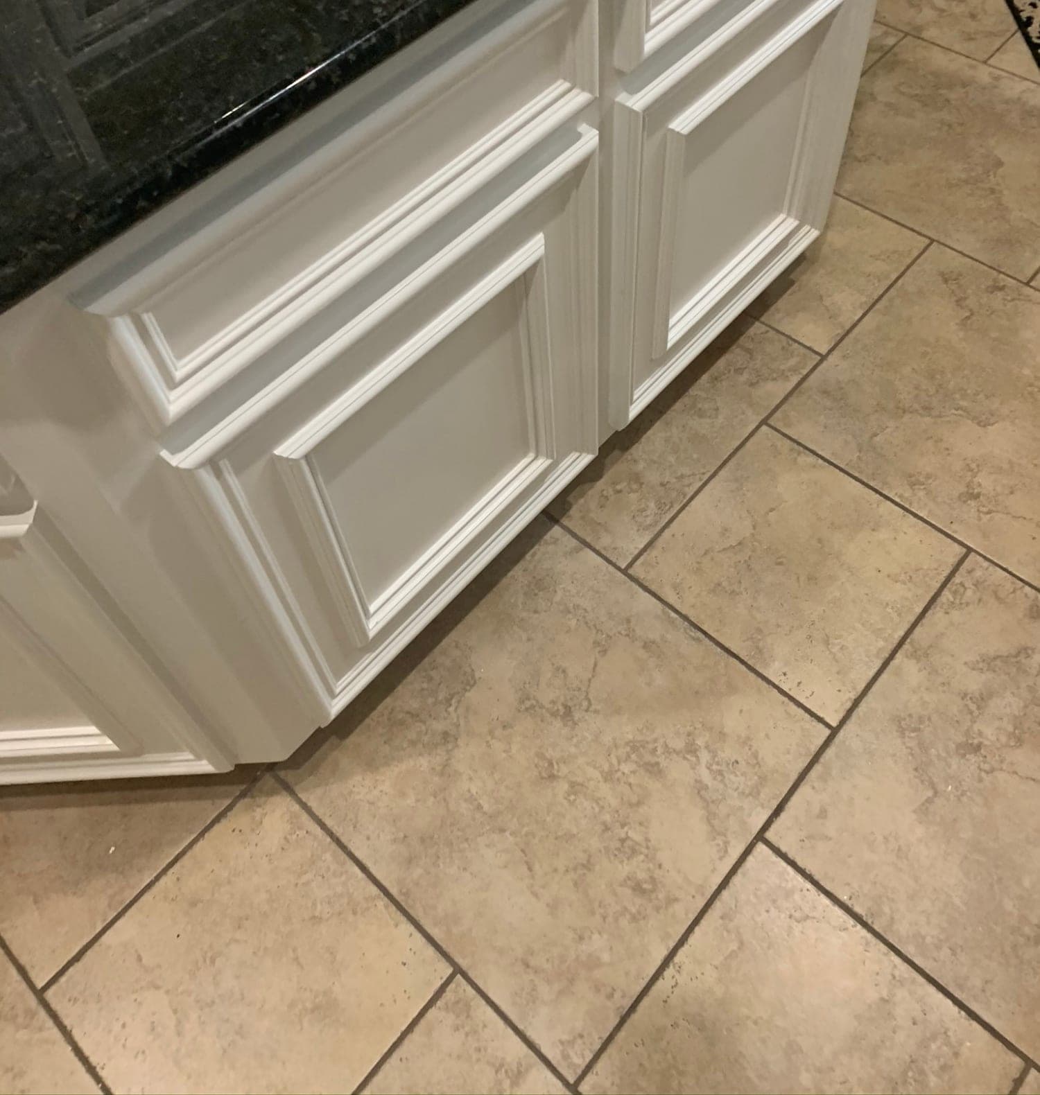 Close view of the white raised-panel doors and drawer fronts on the island