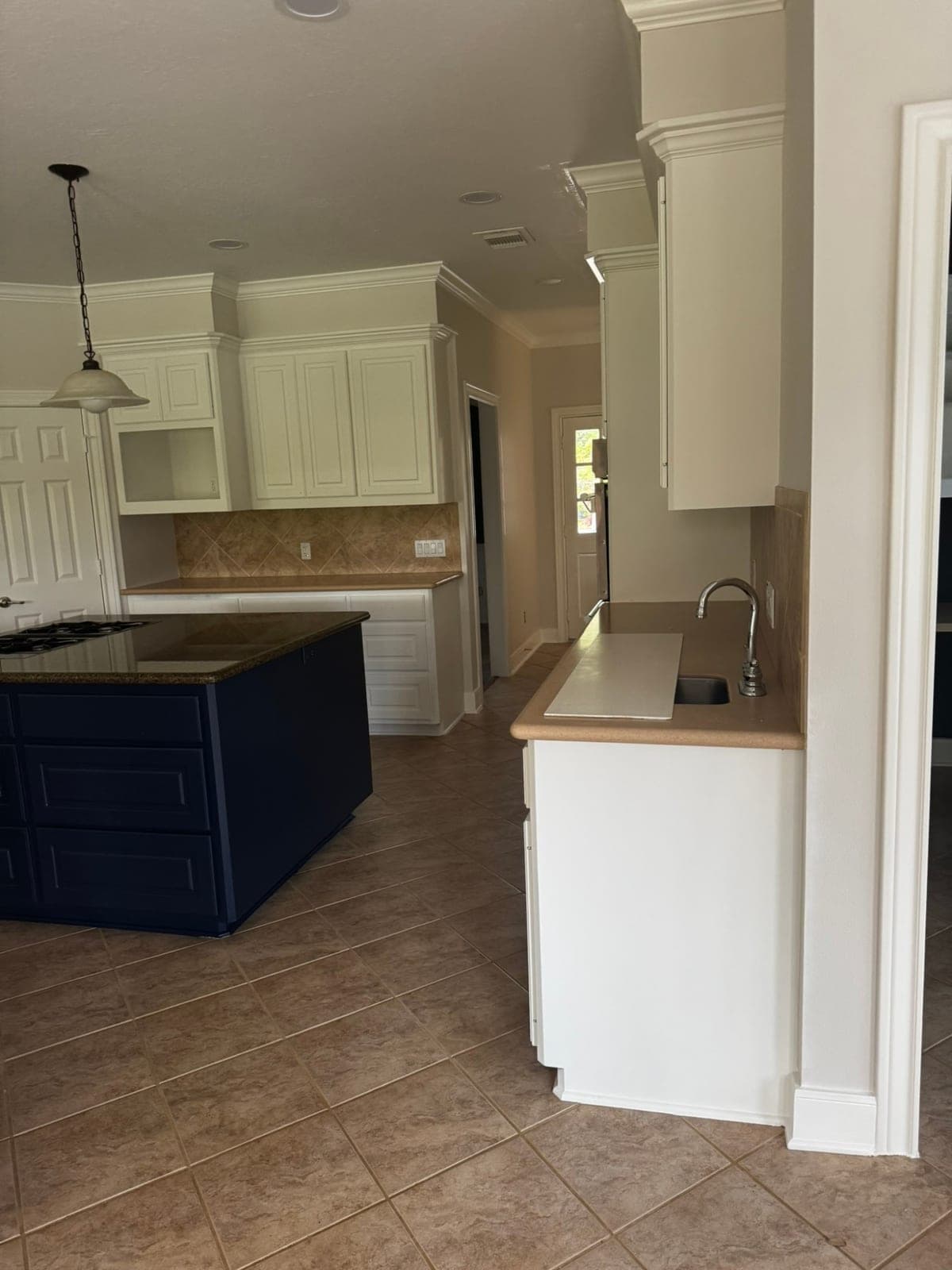 Study with navy walls and ceiling, white crown molding and white built-in desk cabinets