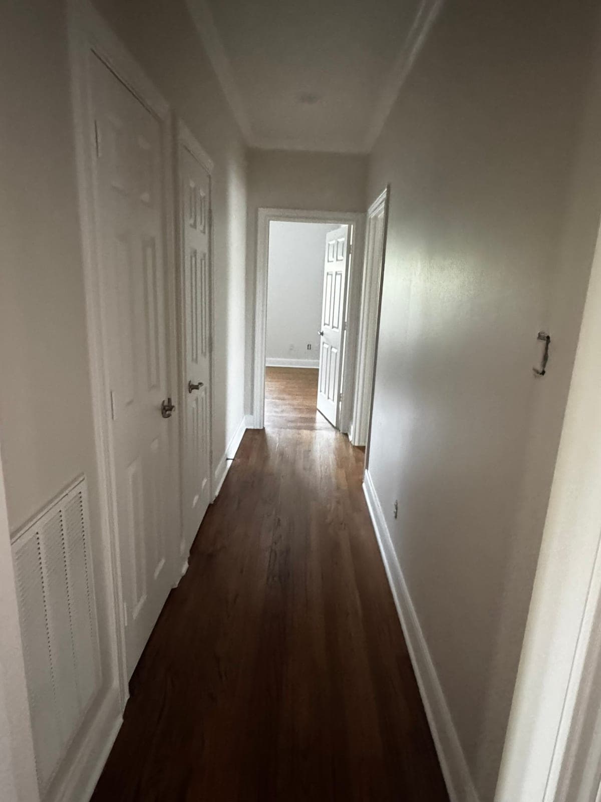 Upstairs hallway with light gray walls, white doors and white baseboards
